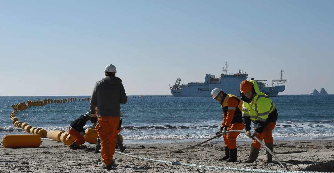 Cable service engineers on beach