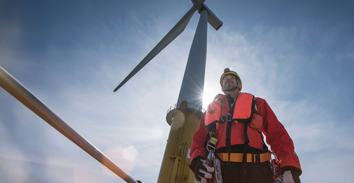 Man standing in front of wind turbine