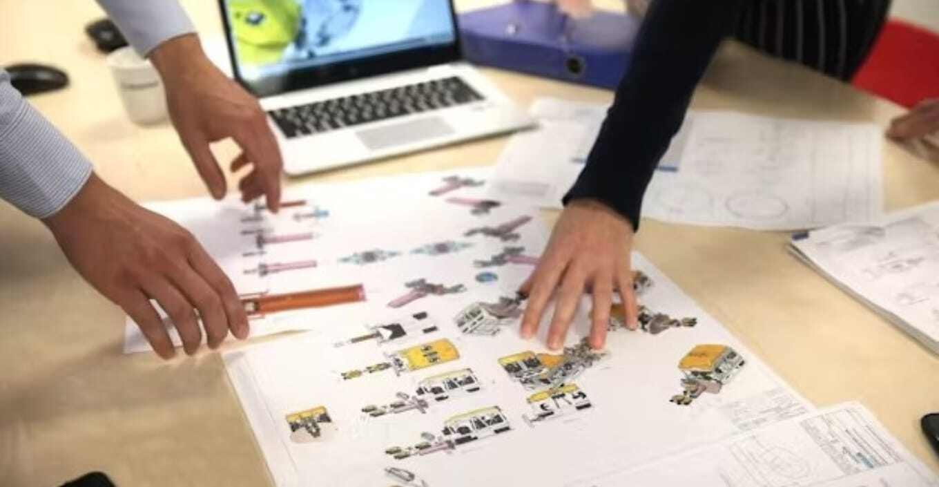 Hands pointing at papers on desk