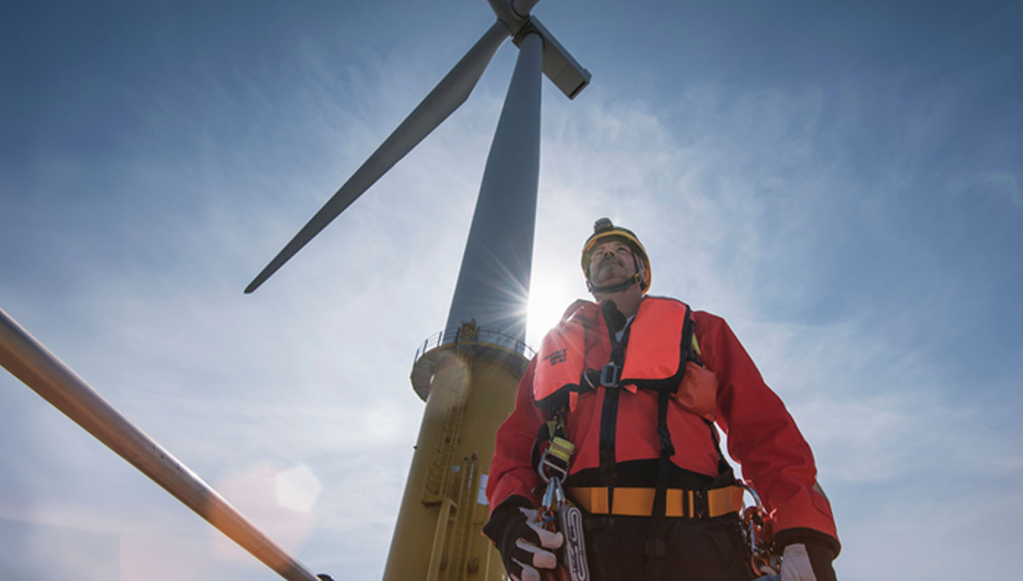 Man standing in front of wind turbine