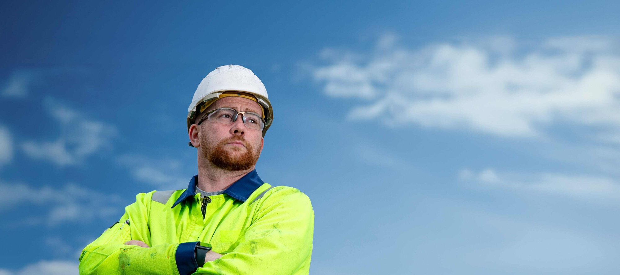 QHSE worker with hard hat and blue sky