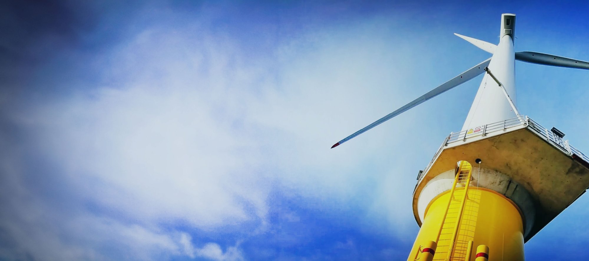 Wind turbine with cloudy blue sky