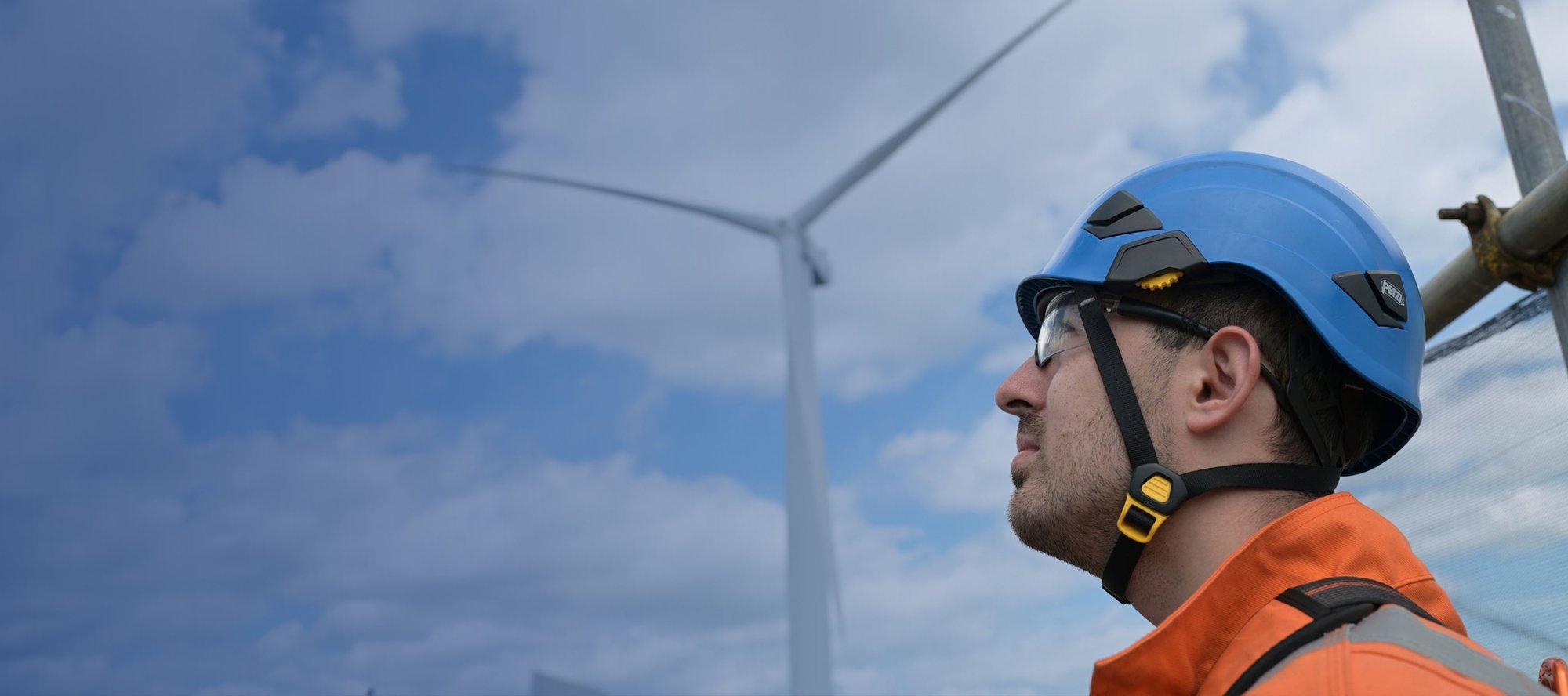 Man looking up to wind turbine