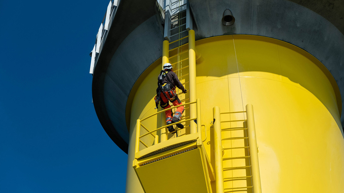 Engineer climbing wind turbine ladder